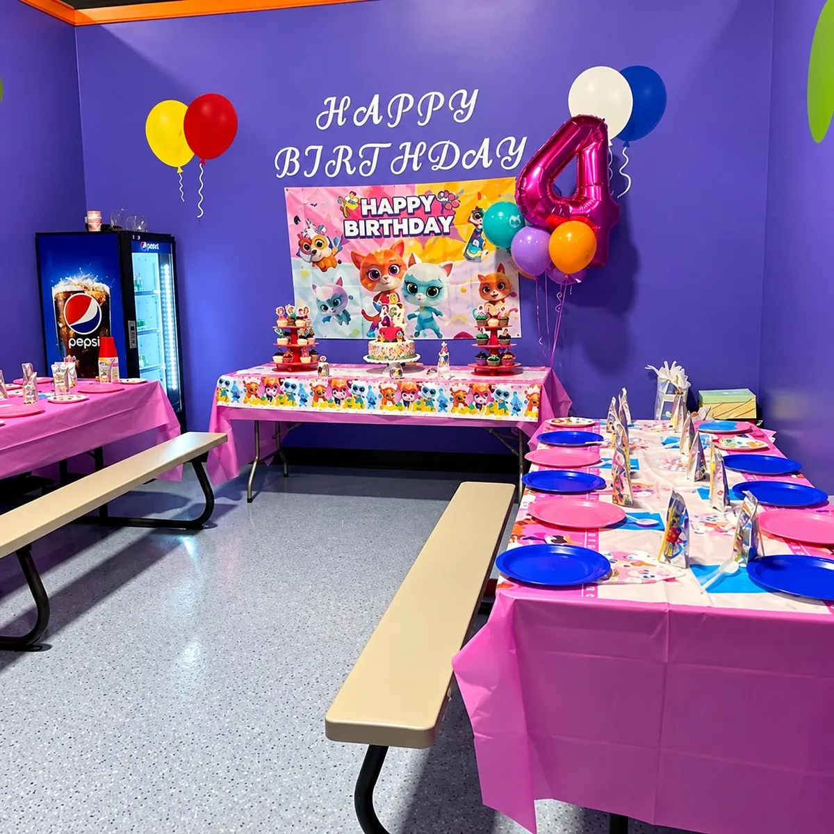 Purple Nova party room decorated for a birthday with Happy Birthday banner, balloons, cake and place settings